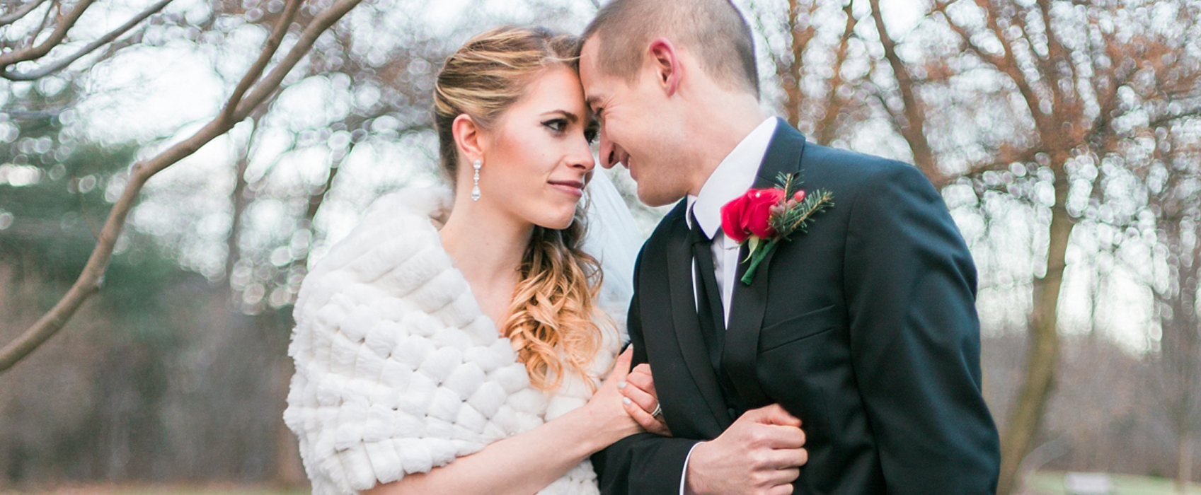 New Jersey Bride magazine feature anne molnar photography publication enchanting winter wedding bride and groom linking arms looking into each others eyes red rose and white rabbit fur stole